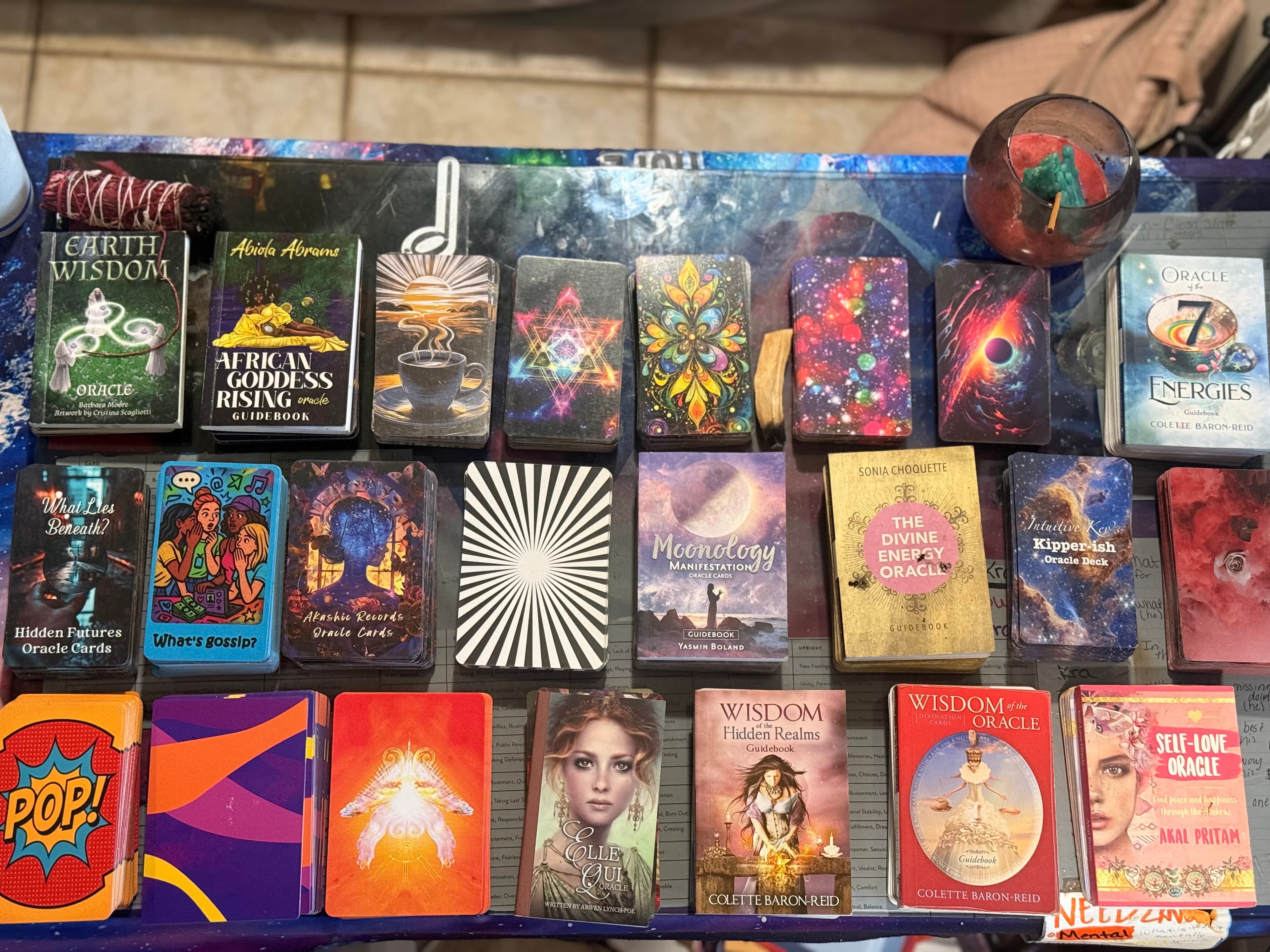Rows of colorful oracle and tarot card decks with mystical themes on a table.