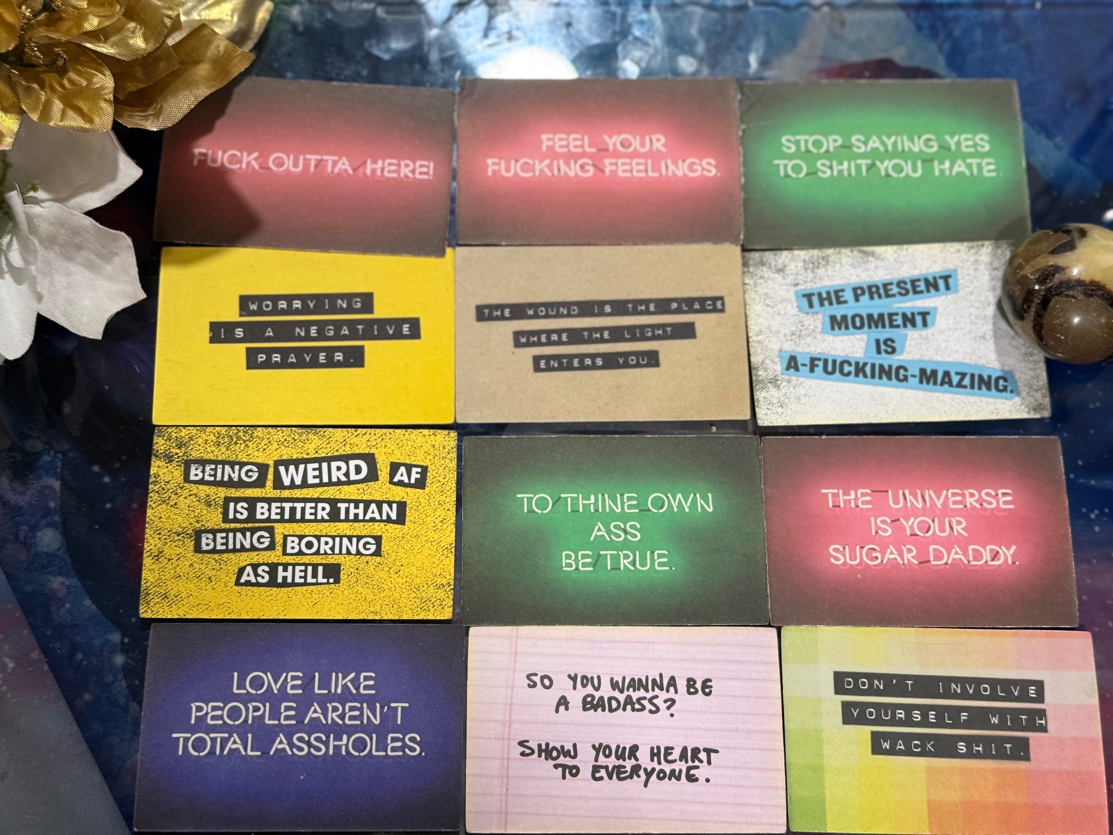 Twelve colorful cards with humorous, profane, and irreverent motivational quotes arranged in a grid.